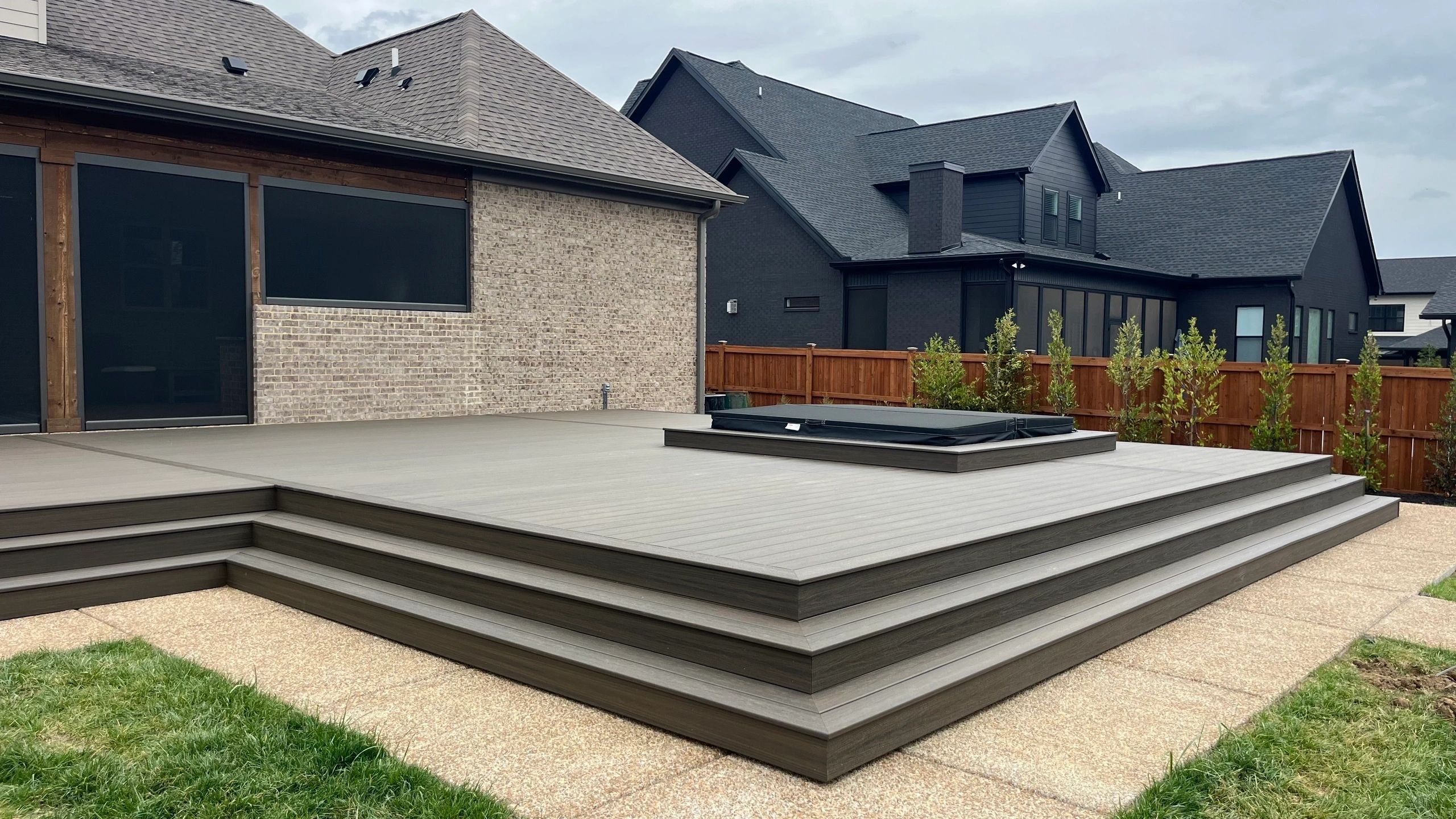 Modern outdoor deck with hot tub and adjacent houses