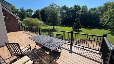 Outdoor deck view with tables and chairs overlooking green landscape