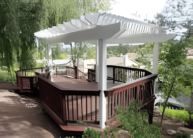 Wooden deck with white pergola overlooking garden